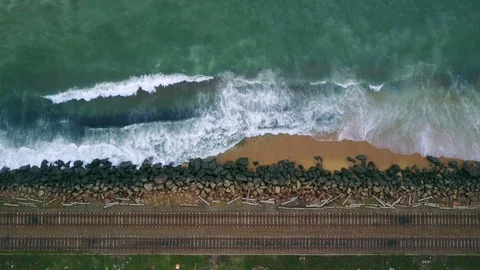 Aerial view of ocean wave reaching coast rocks with railway along the coastline Stock-Footage 124401374