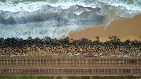 Aerial view of ocean wave reaching coast rocks with railway along the coastline Stock-Footage 124405151