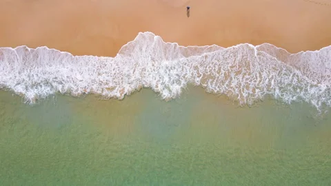 Aerial view of ocean wave reaching the coastline with a man fishing 스톡 동영상 170829239