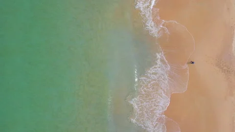 Aerial view of ocean wave reaching the coastline with a man fishing 스톡 동영상 170833284