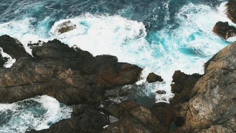 Aerial view of the ocean waves and the beautiful rocky coast of the island of Stock Footage 112034460