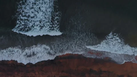 Aerial view to ocean waves and red sand beach. Blue sea water background Stock Footage 303736599