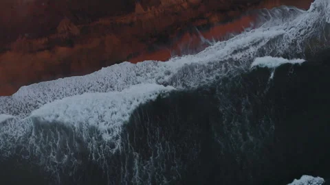 Aerial view to ocean waves and red sand beach. Blue sea water background Stock Footage 303736826