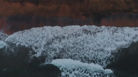 Aerial view to ocean waves and red sand beach. Blue sea water background Stock Footage 303736833