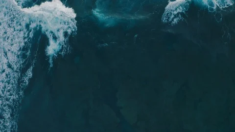 Aerial view ocean waves break into foam along the shore Stock Footage 111834131