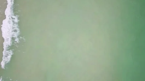 Aerial View of Ocean Waves Breaking on Sandy Beach Stock Footage 310243750