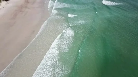 Aerial View of Ocean Waves Breaking on Sandy Shore Video stock 310244812