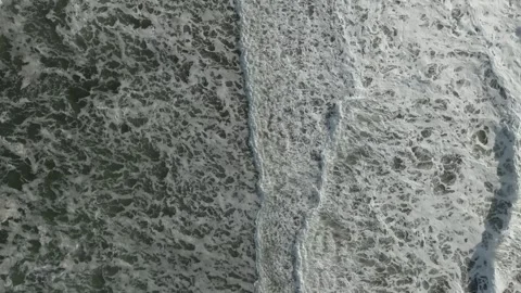 Aerial view of ocean waves breaking with sea foam texture and surf patterns Video stock 336295477