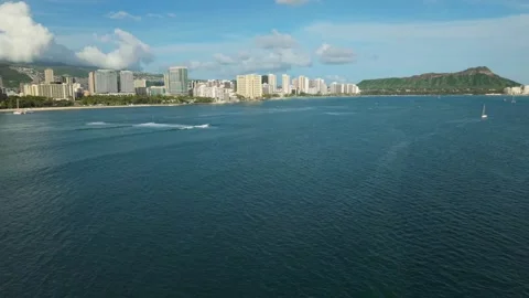 Aerial view of ocean waves breaking over reef with surfers in Waikiki Stock Footage 346427363