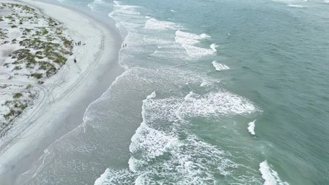 Aerial view of ocean waves crashing on sandy beach Stock Footage 323914389