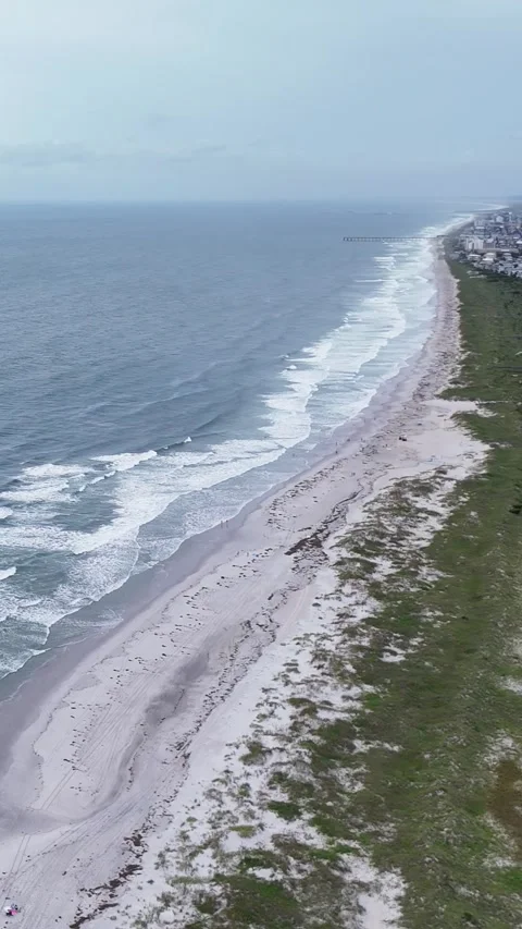 Aerial view of ocean waves crashing on sandy beach Stock Footage 323915048