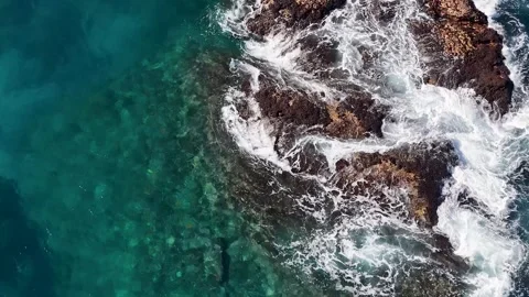 Aerial View of Ocean Waves Crashing Against Coastal Rocks Video stock 342086310