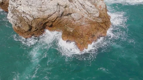Aerial View of Ocean Waves Crashing Against Rugged Coastal Rock Formation Stock Footage 342091796