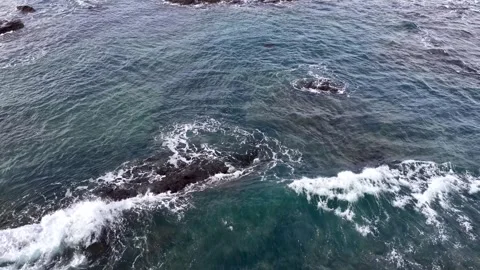 Aerial View of Ocean Waves Crashing Over Dark Coastal Rocks 스톡 동영상 344946114