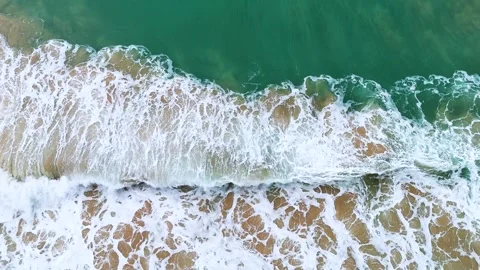 Aerial View of Ocean Waves Forming Patterns on Sandy Shoreline Stock Footage 321822326