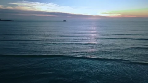Aerial view of ocean waves on rocky shoreline at sunset Stock Footage 331194443