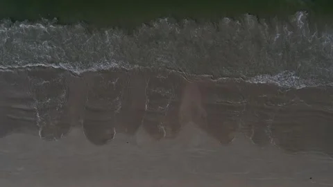 Aerial view of ocean waves onto a sandy beach in Phuket, Thailand Stock Footage 327527177