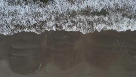 Aerial view of ocean waves onto a sandy beach in Phuket, Thailand Stock Footage 327527232
