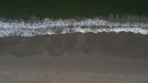 Aerial view of ocean waves onto a sandy beach in Phuket, Thailand Stock Footage 327527282