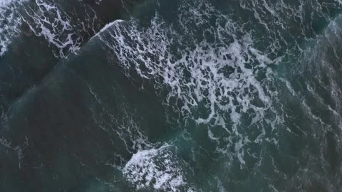 Aerial view of the ocean's dynamic waves with white frothy crests against deep Stock Footage 309622856