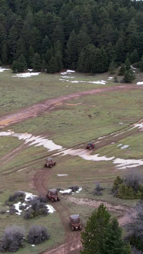 Aerial view of offroad ATVs on muddy paths in snowy mountain field Stock Footage 343992860
