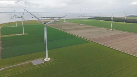Aerial view of offshore-style wind turbines along the coast of Almere Pampus Vidéo 343620998