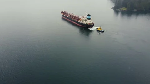 Aerial view of the oil tanker pulled by tug boat in a calm water in Canada Stock Footage 151725938
