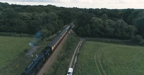 Aerial view of an old fashioned steam train crossing the English countryside Stock Footage 79104517