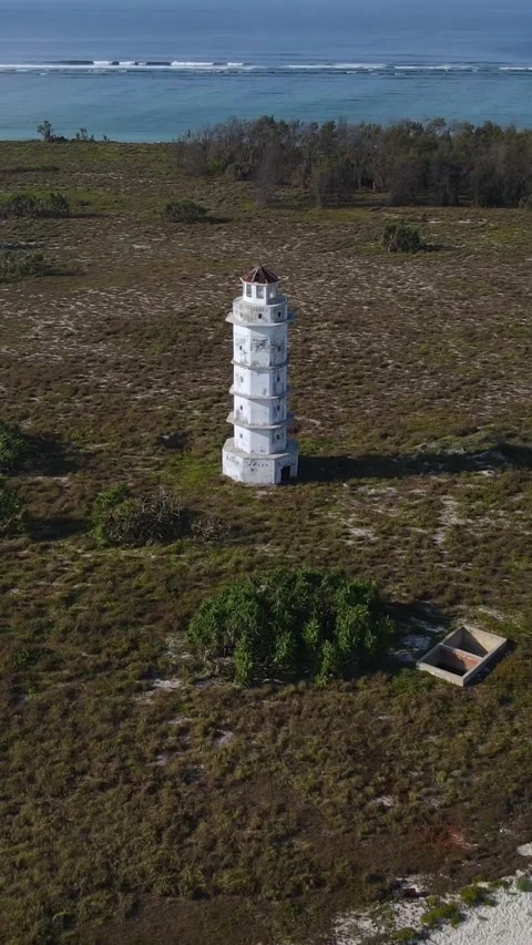 Aerial view of old lighthouse at ocean coastline.Vertical video Stock Footage 300431283