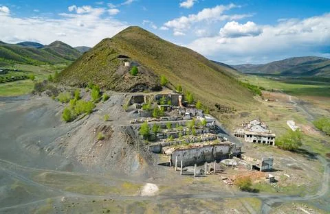 Aerial view of an old mining site with abandoned buildings and overgrown la.. 스톡 사진