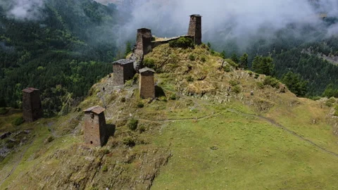 Aerial view of old monastery ruins on a hill with mountains in the background Stock Footage 229880429