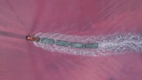 Aerial view of an old train rides on the railway laid in the water through the Stock Footage 231602365