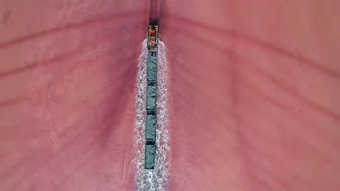 Aerial view of an old train rides on the railway laid in the water through the Stock Footage 231602441