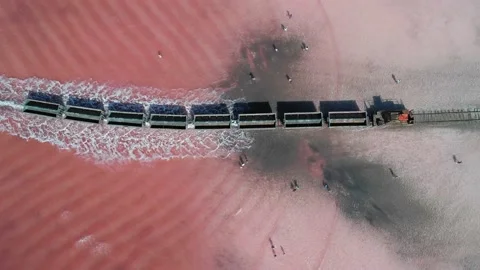 Aerial view of an old train rides on the railway laid in the water through the Stock Footage 231602445