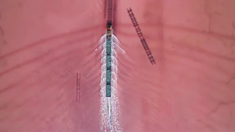 Aerial view of an old train rides on the railway laid in the water through the Stock Footage 231602534