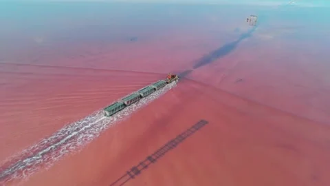 Aerial view of an old train rides on the railway laid in the water through the Stock Footage 231602565