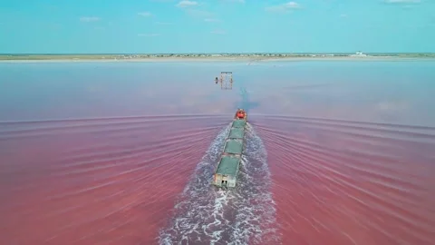 Aerial view of an old train rides on the railway laid in the water through the Stock Footage 231602570