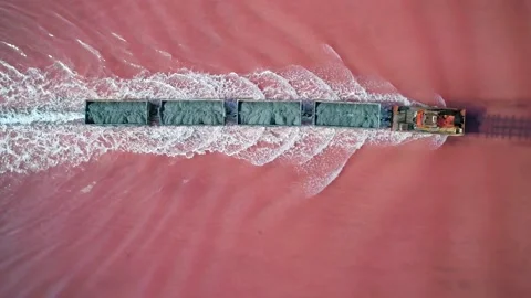 Aerial view of an old train rides on the railway laid in the water through the Stock Footage 231602649
