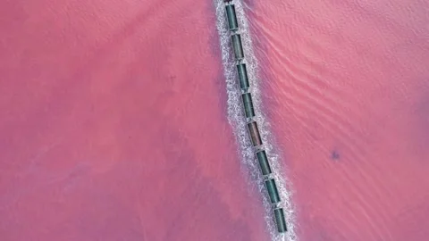 Aerial view of an old train rides on the railway laid in the water through the Stock Footage 231602655