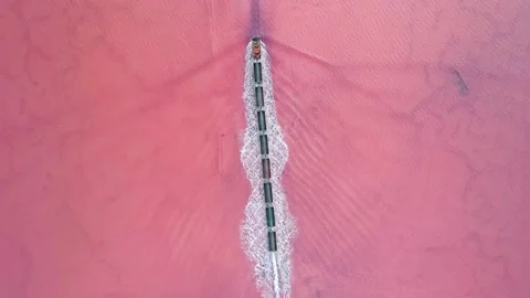 Aerial view of an old train rides on the railway laid in the water through the Stock Footage 231602665