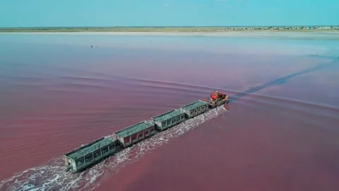 Aerial view of an old train rides on the railway laid in the water through the Stock Footage 231603073