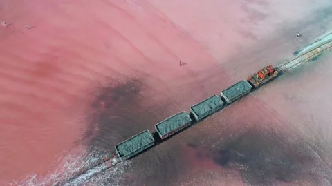 Aerial view of an old train rides on the railway laid in the water through the Stock Footage 231603090