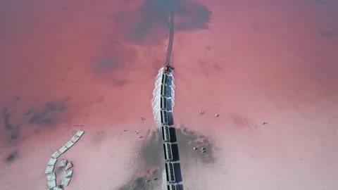 Aerial view of an old train rides on the railway laid in the water through the Stock Footage 250452148