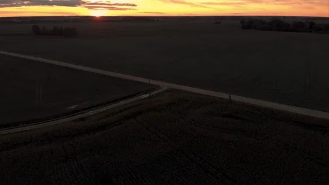 Aerial view of old white soviet car driving on dirt road in dark at sunset Stock Footage 127849608
