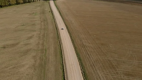 Aerial view of old white soviet retro car driving on dirt road Stock Footage 127849610