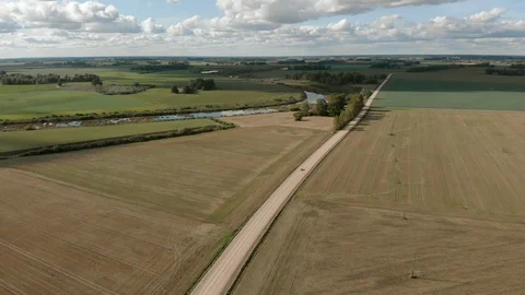Aerial view of old white soviet retro car driving on dirt road by river Stock Footage 127849728