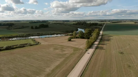 Aerial view of old white soviet retro car driving on dirt road by river Stock Footage 127849752