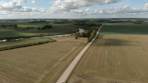 Aerial view of old white soviet retro car driving on dirt road by river Stock Footage 127849782