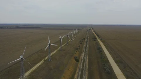 Aerial view old wind power generators spinning in the filed with road. Stock Footage 118742733