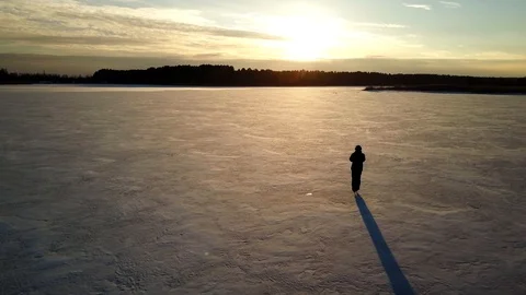 Aerial view: One man is skating on the ice of frozen river during beautiful Stock Footage 104746545